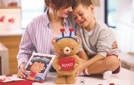 A mother and son looking at the Love Cub Bear Plush and From the Heart: Bear Finds Just the Write Words Book 